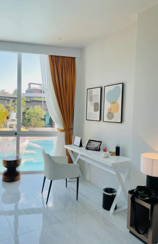 Modern hotel room with workspace and pool view at Pattaya resort.